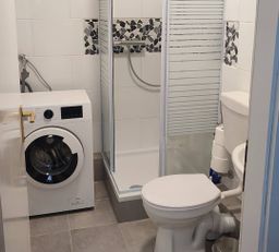 Badezimmer mit Dusche und Waschmaschine